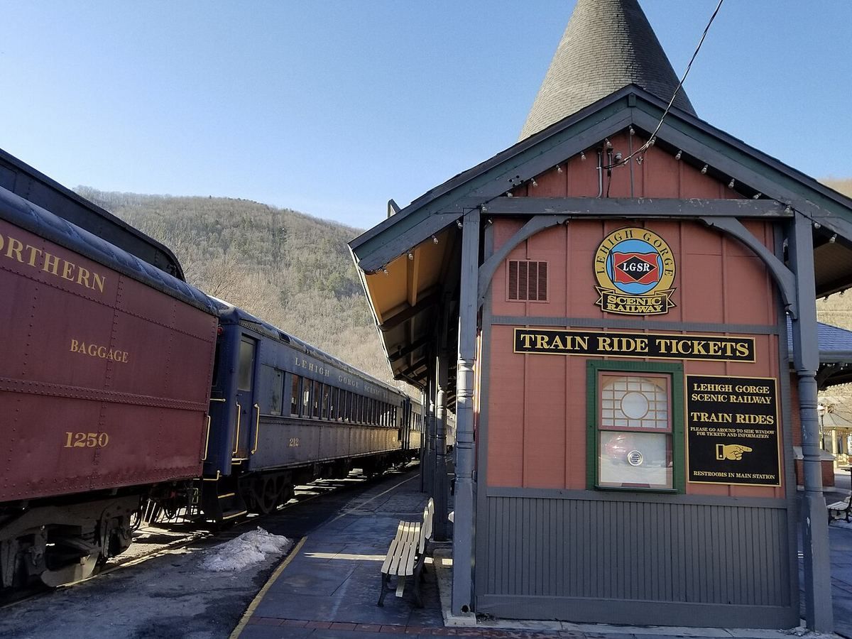 Maroon passenger coaches of the Lehigh Gorge Scenic Railway waiting beside the timber ticket office at Jim Thorpe station.