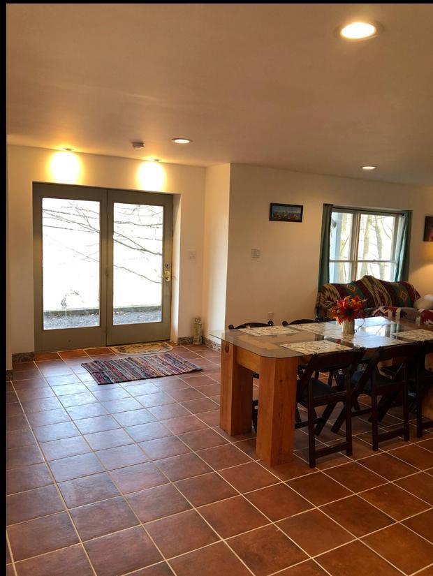 Entrance hall with a terracotta tiled floor looking through to a wooden dining table.