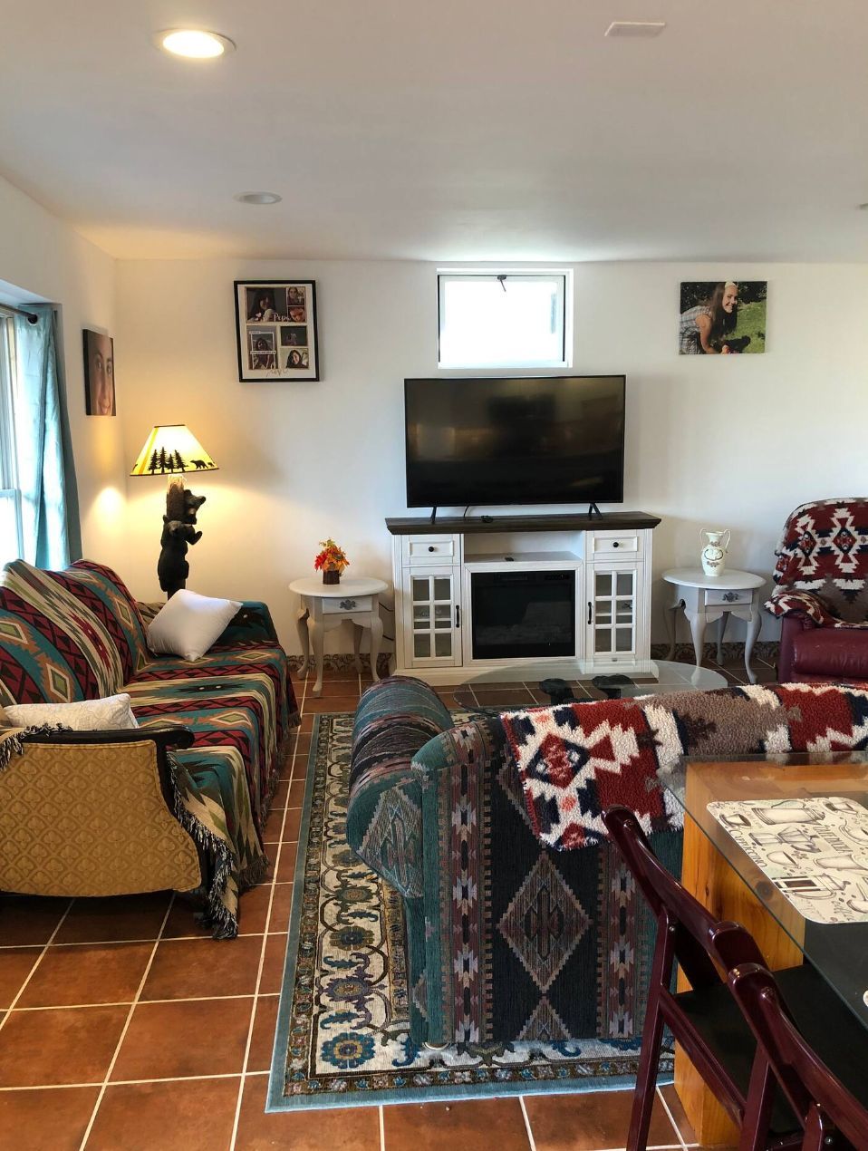 Apartment living room with two sofas, a patterned rug, television and a doorway through to the dining area.